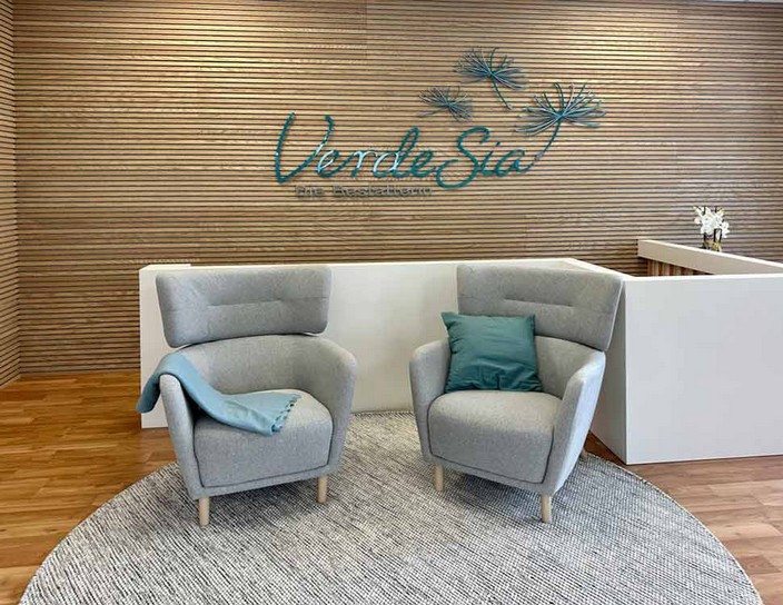 Zwei Sessel im Firmengebäude vor einer holzvertäfelten Wand mit VerdeSia-Firmenlogo